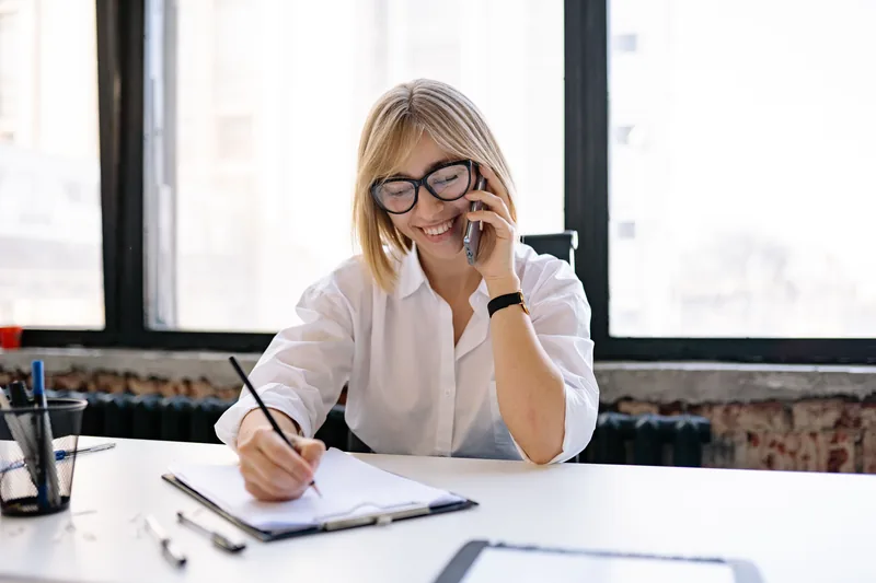 Office worker on a phone call taking notes